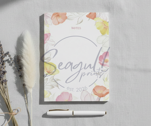 A regular floral note pad featuring a botanical border on smooth A6 cream paper, perfect for a professional desktop.